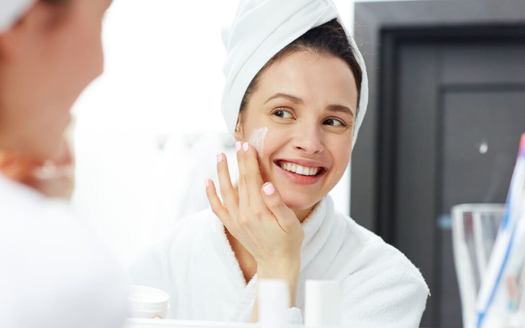 woman applying cream to face