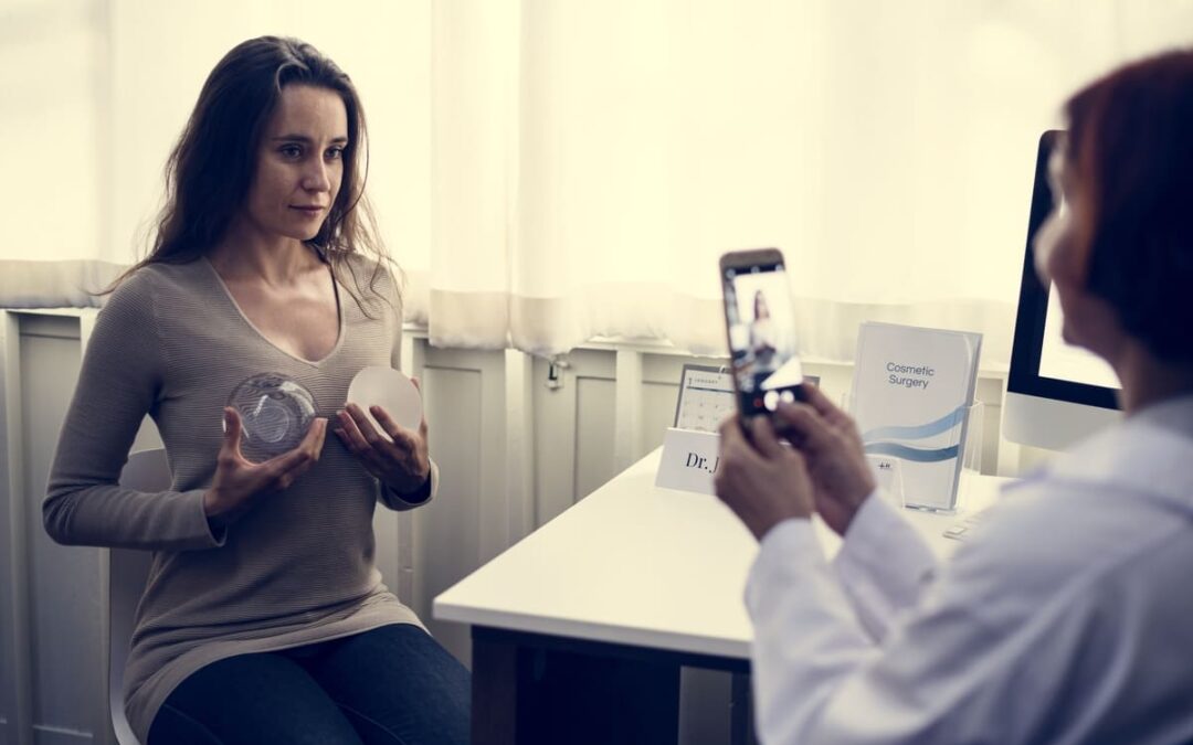 woman holding implants to chest thinking